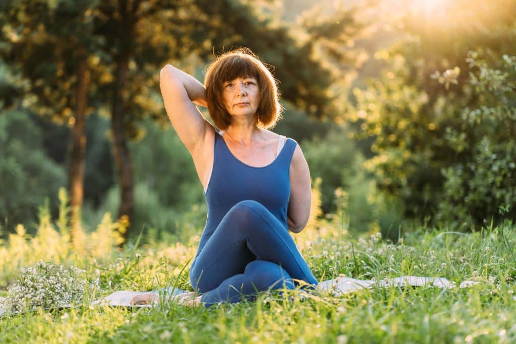 Frau im Park macht Yoga