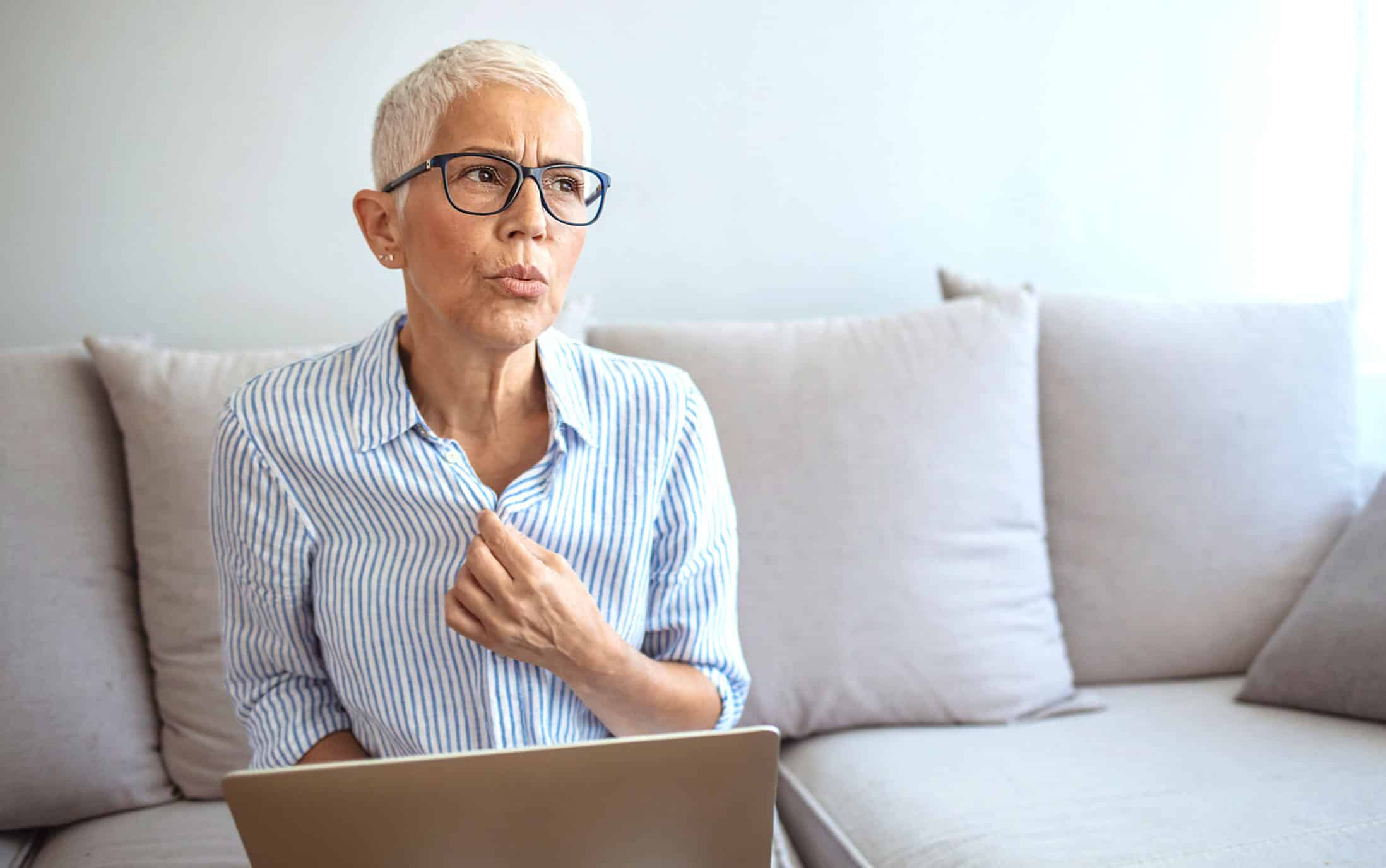 Nachdenkliche Frau mit Notebook auf der Chouch