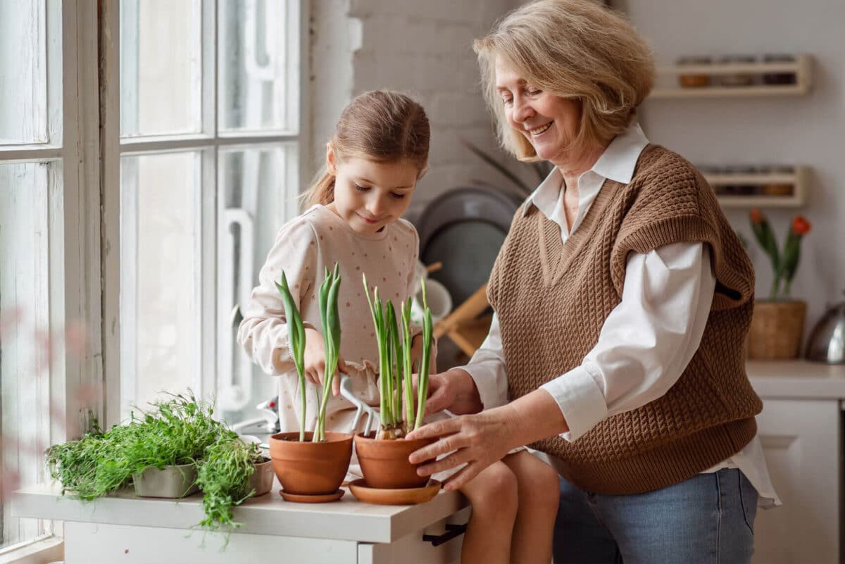 Oma und Enkeltochter mit den Pflanzen in der Küche